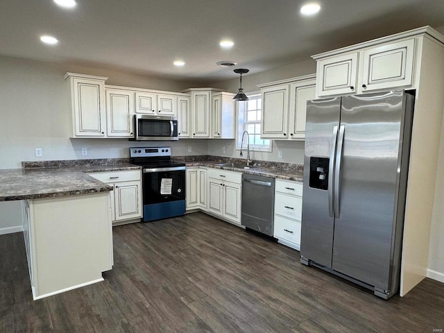 kitchen with stainless steel appliances, white cabinets, hanging light fixtures, dark hardwood / wood-style floors, and sink