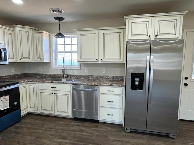 kitchen featuring dark hardwood / wood-style flooring, sink, stainless steel appliances, and decorative light fixtures