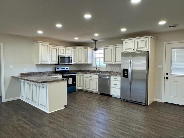 kitchen with dark hardwood / wood-style flooring, decorative light fixtures, stainless steel appliances, and kitchen peninsula