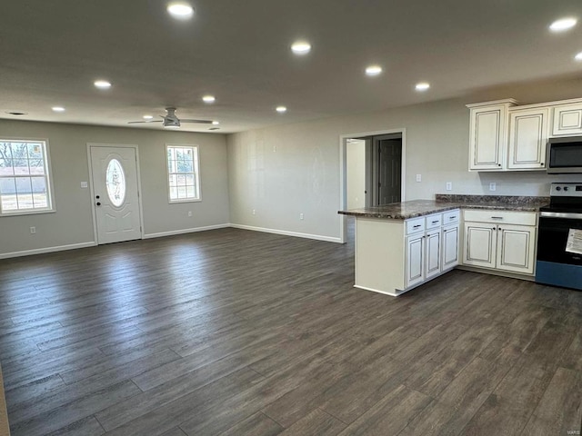 kitchen featuring stainless steel appliances, a healthy amount of sunlight, ceiling fan, and dark hardwood / wood-style flooring