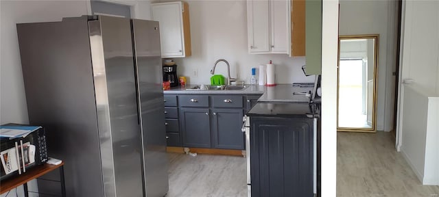 kitchen featuring appliances with stainless steel finishes, gray cabinetry, sink, and light wood-type flooring