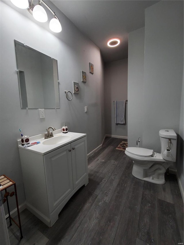 bathroom with hardwood / wood-style floors, toilet, and vanity