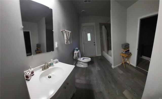 bathroom with walk in shower, toilet, vanity, and wood-type flooring