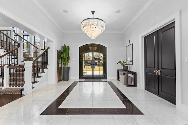 foyer entrance featuring crown molding, a healthy amount of sunlight, and a chandelier