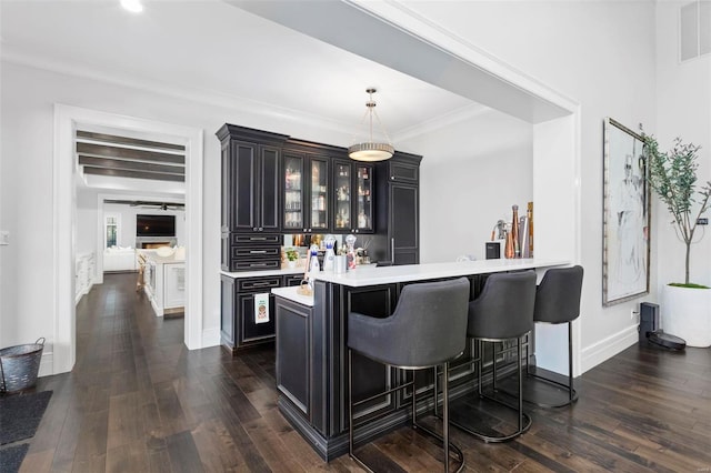 kitchen with pendant lighting, kitchen peninsula, dark hardwood / wood-style floors, and a breakfast bar