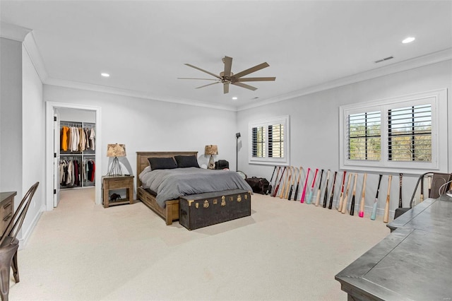 bedroom with a spacious closet, a closet, ornamental molding, carpet flooring, and ceiling fan