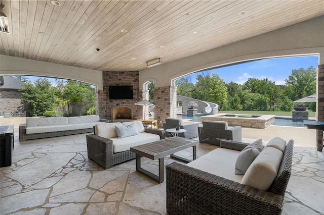 view of patio with an outdoor living space with a fireplace