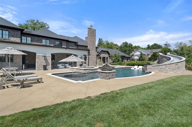 view of pool with an in ground hot tub, a lawn, and a patio