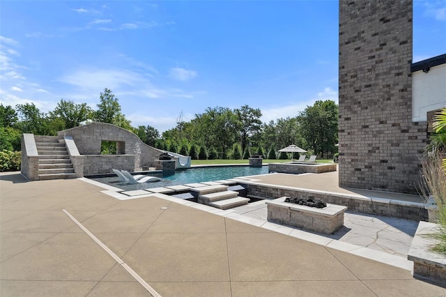 view of swimming pool with pool water feature and a patio