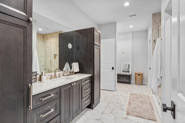 bathroom with a shower with door and vanity