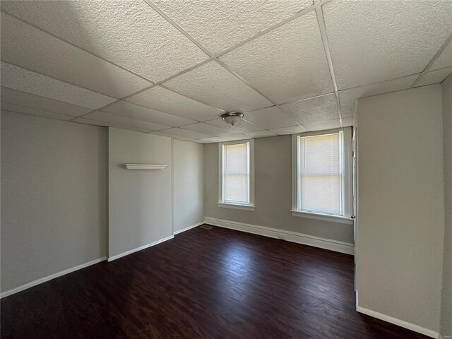 spare room with dark hardwood / wood-style floors and a paneled ceiling