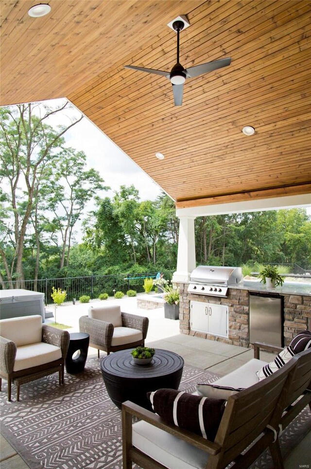 view of patio with a grill, an outdoor hangout area, ceiling fan, and exterior kitchen