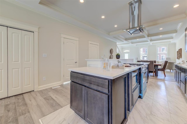 kitchen with coffered ceiling, island exhaust hood, an island with sink, ornamental molding, and beamed ceiling