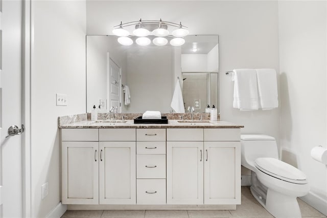 bathroom featuring tile patterned flooring, vanity, toilet, and a shower with shower door