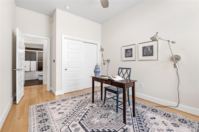 home office with ceiling fan and light hardwood / wood-style floors