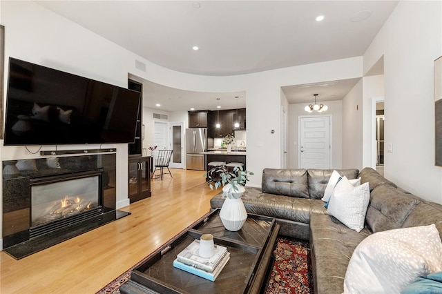 living room featuring an inviting chandelier and light wood-type flooring