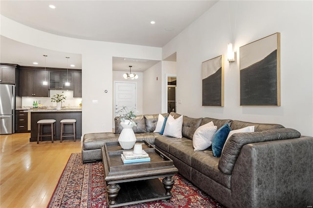 living room with light hardwood / wood-style flooring and a notable chandelier