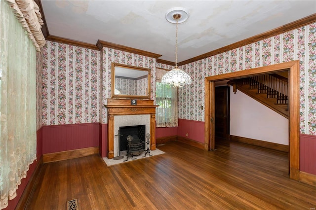 unfurnished living room featuring ornamental molding, dark hardwood / wood-style floors, and a chandelier