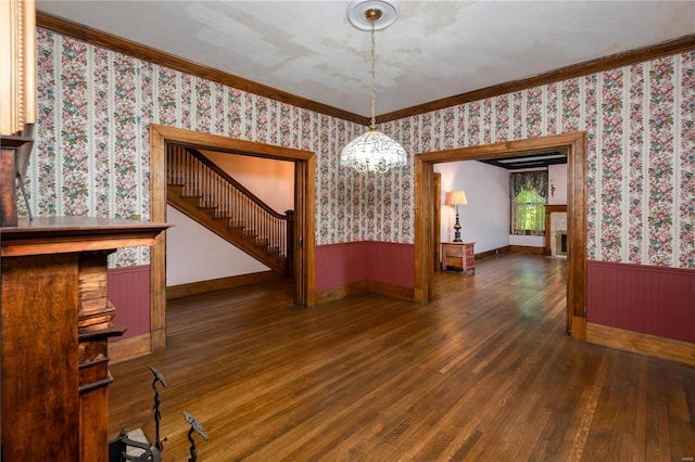 unfurnished dining area with ornamental molding, dark hardwood / wood-style floors, and a notable chandelier