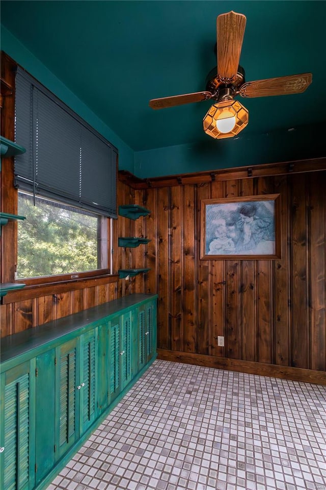 interior space with wooden walls and ceiling fan