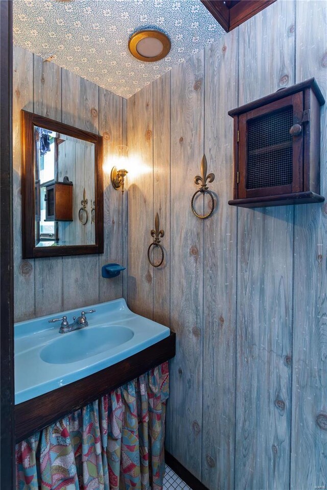 bathroom featuring vanity and wood walls