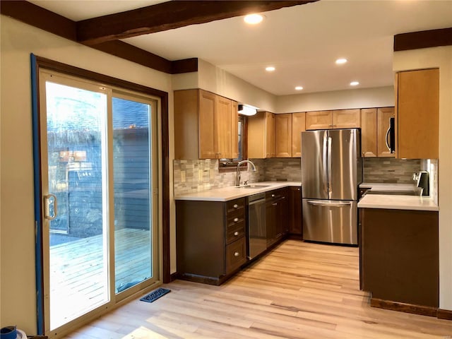 kitchen with sink, beamed ceiling, light hardwood / wood-style floors, backsplash, and appliances with stainless steel finishes