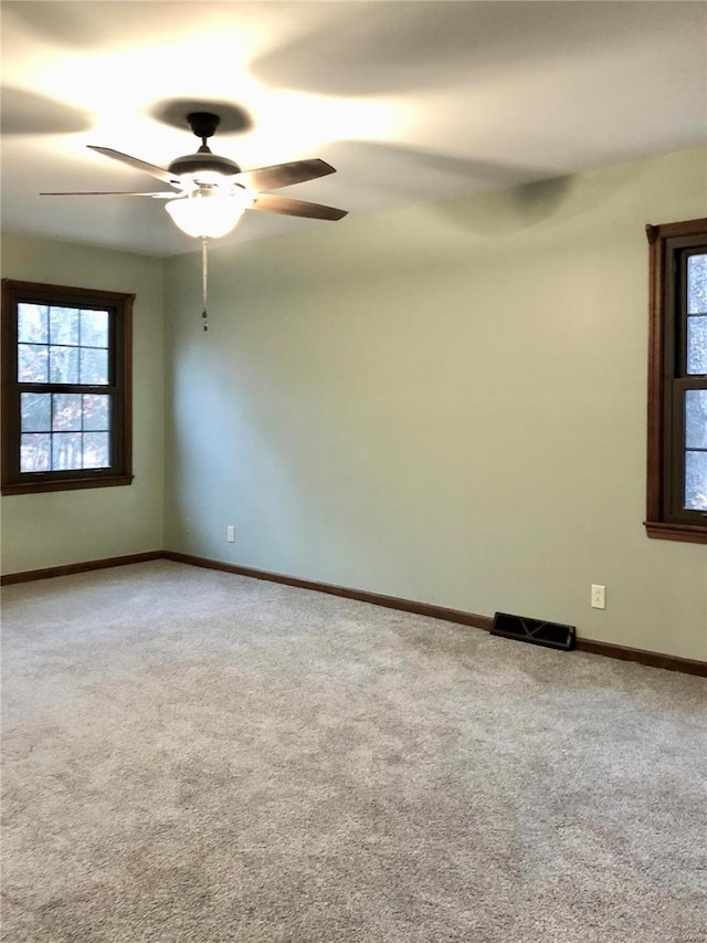 empty room with ceiling fan and carpet floors