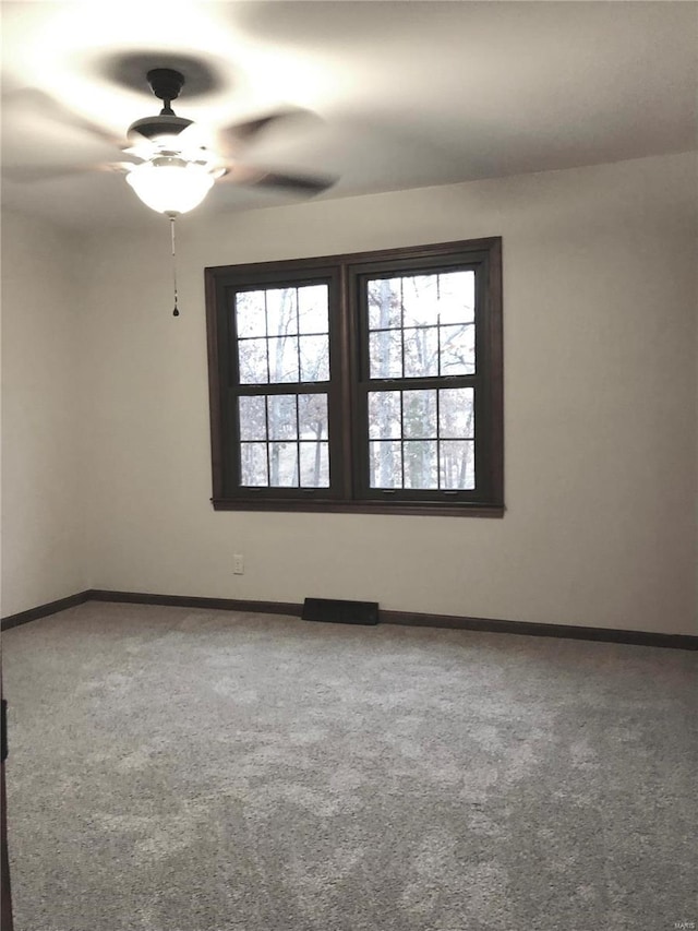 carpeted spare room with ceiling fan