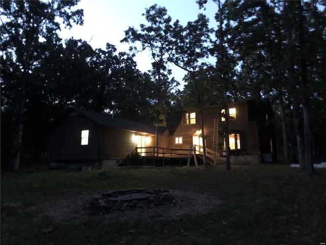 back house at dusk with a wooden deck