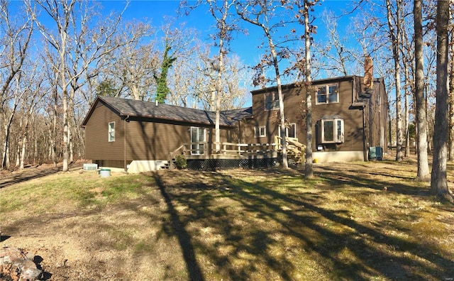 rear view of property featuring a yard and a wooden deck