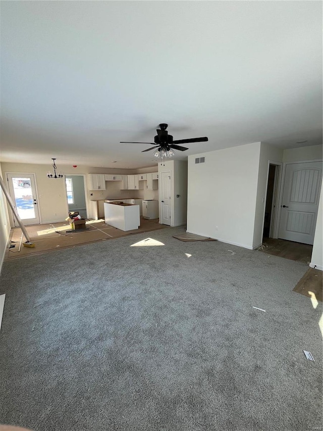 unfurnished living room featuring carpet flooring and ceiling fan