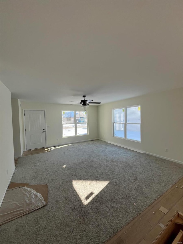 unfurnished living room featuring ceiling fan and carpet floors