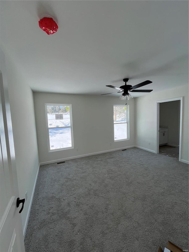 empty room featuring carpet flooring and ceiling fan