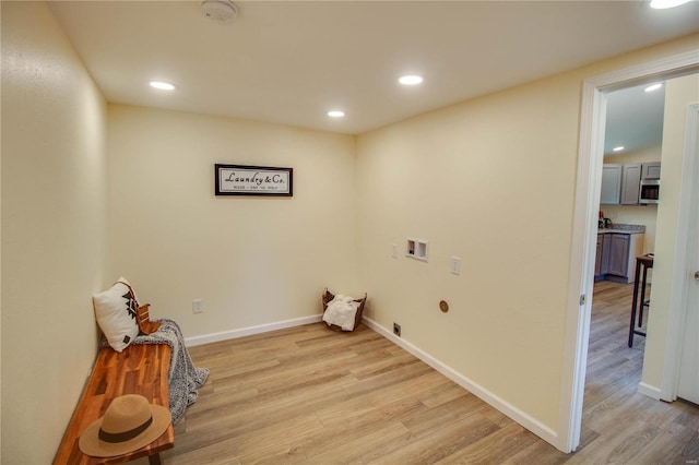 clothes washing area featuring electric dryer hookup, light hardwood / wood-style floors, and hookup for a washing machine