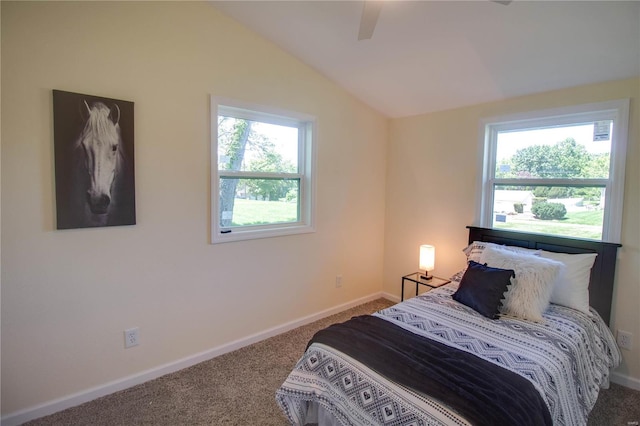 carpeted bedroom with multiple windows, ceiling fan, and vaulted ceiling