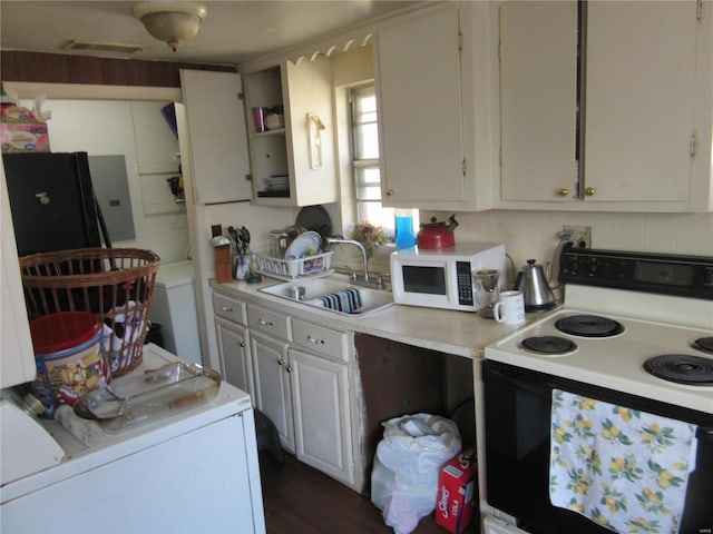 kitchen featuring tasteful backsplash, white appliances, white cabinets, washer / dryer, and sink