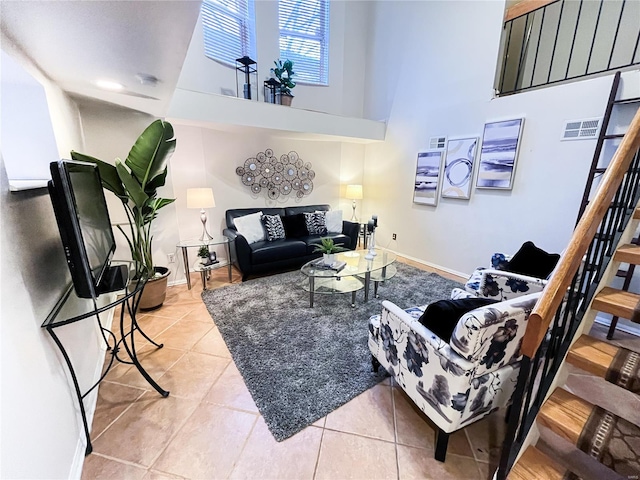 tiled living room featuring a towering ceiling