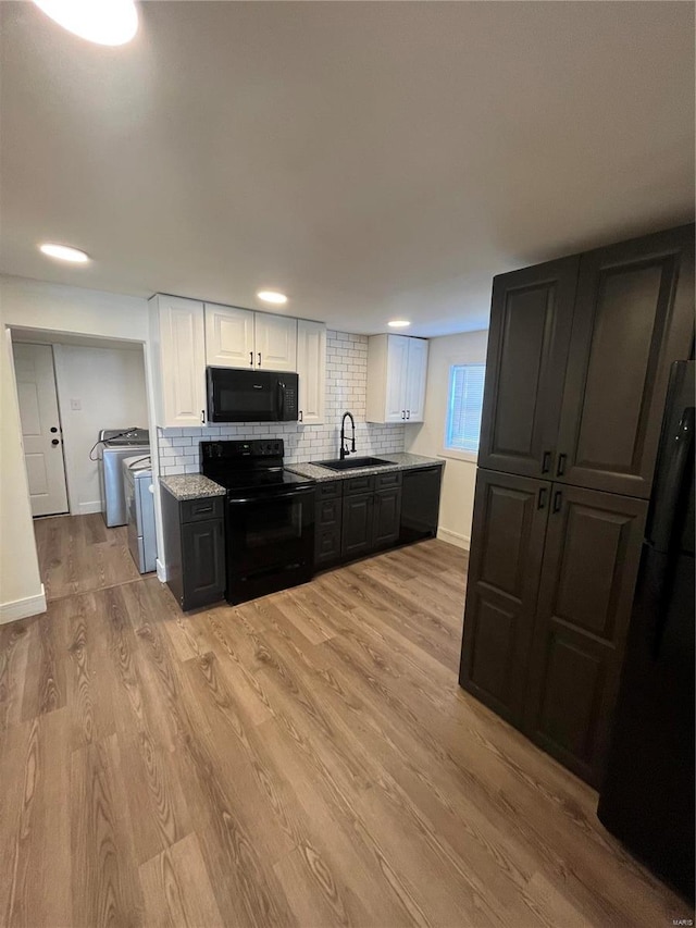 kitchen featuring white cabinets, black appliances, backsplash, sink, and light hardwood / wood-style floors