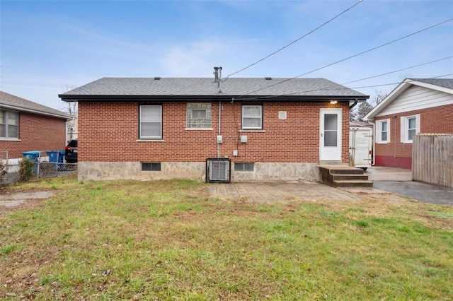 rear view of property featuring a yard and central AC unit