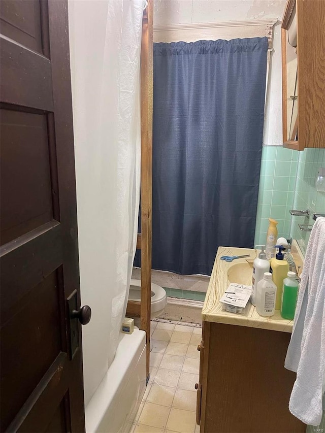 bathroom with vanity, tile patterned flooring, toilet, and tile walls