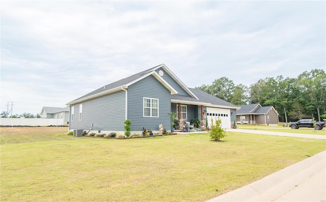 view of front of property featuring a front lawn, a garage, and central air condition unit