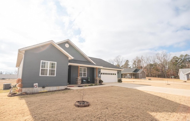 view of front of home featuring a garage, a fire pit, and central air condition unit