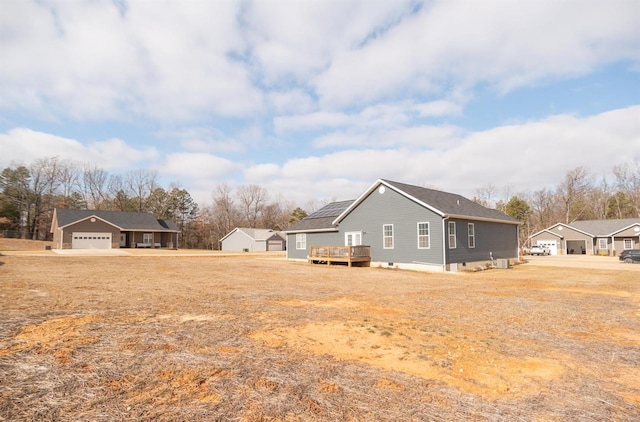 view of yard featuring a garage and a wooden deck