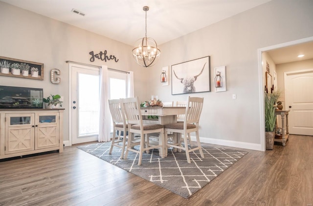 dining area with an inviting chandelier, wood finished floors, visible vents, and baseboards