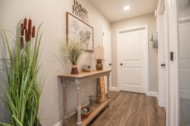 corridor featuring baseboards and wood finished floors