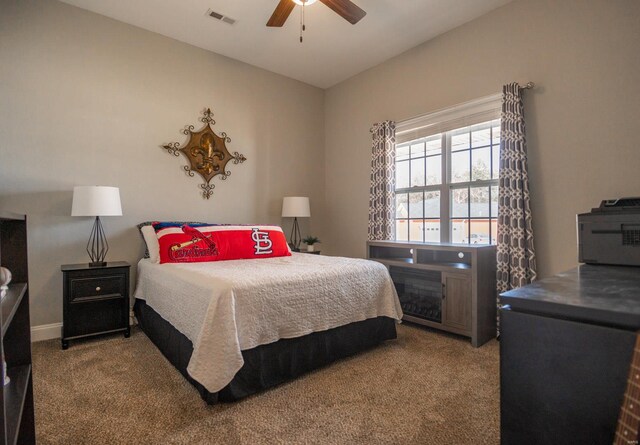 carpeted bedroom with vaulted ceiling, visible vents, and ceiling fan