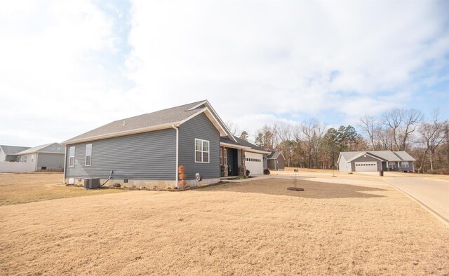 view of home's exterior with driveway, an attached garage, and central air condition unit