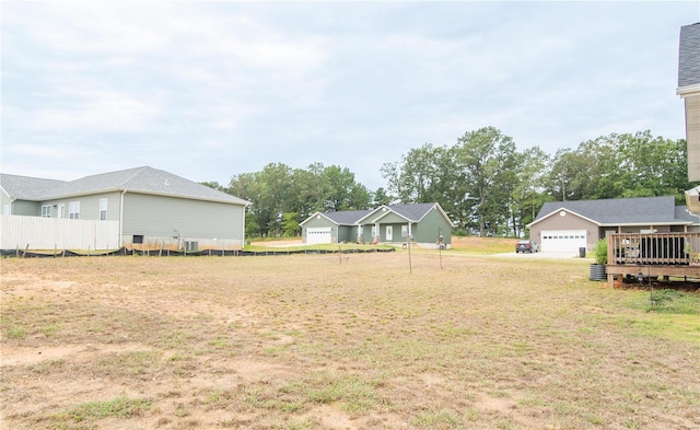 view of yard featuring a garage and central AC unit