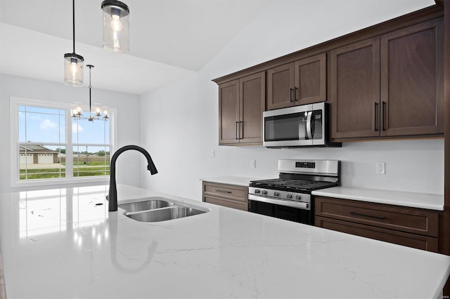 kitchen featuring stainless steel appliances, sink, an inviting chandelier, hanging light fixtures, and lofted ceiling