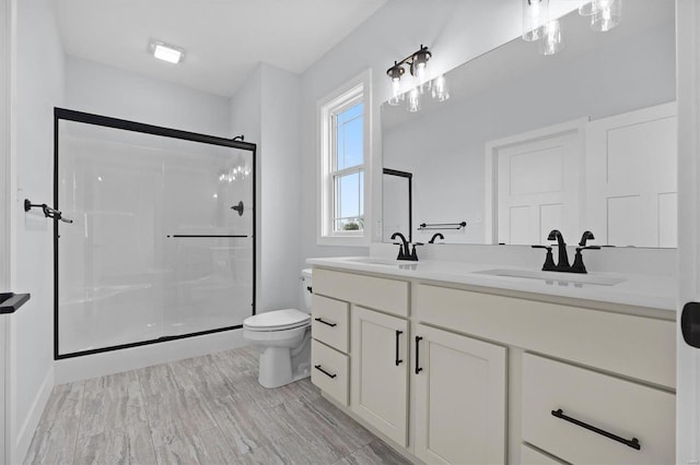 bathroom with an enclosed shower, vanity, hardwood / wood-style flooring, and toilet